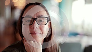 pretty middle-aged woman with glasses for correcting vision is looking at camera