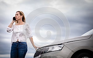 Pretty middle aged woman having car troubles