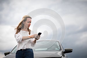 Pretty middle aged woman having car troubles