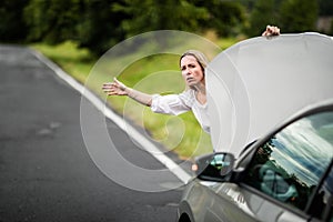 Pretty middle aged woman having car troubles