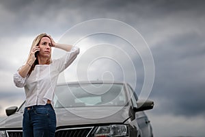 Pretty middle aged woman having car troubles