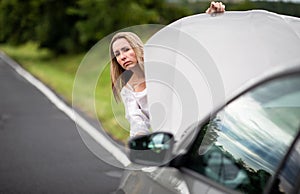 Pretty middle aged woman having car troubles