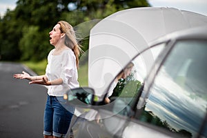 Pretty middle aged woman having car troubles