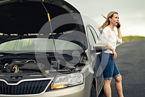 Pretty middle aged woman having car troubles