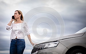 Pretty middle aged woman having car troubles photo