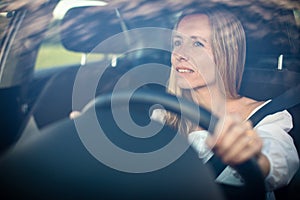 Pretty middle aged woman at the steering wheel