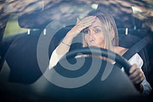 Pretty middle aged woman at the steering wheel