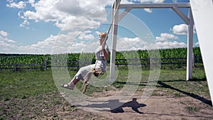 Pretty middle aged woman swinging on an outdoor swing