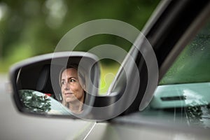 Pretty midle aged woman at the steering wheel of her car