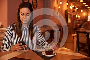 Pretty millenial in restaurant with phone