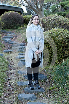 Pretty mixed race 40-49 year old woman wearing glasses smiling. Full body front view.