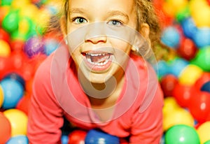 Pretty mixed race female child having fun in children playground indoor - Portrait of little happy girl playing in kindergarten -