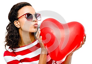 Pretty mixed race girl holding red heart balloon