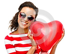 Pretty mixed race girl holding red heart balloon