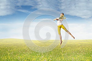 Pretty model with flower jumps on meadow