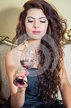 Pretty model girl sitting on victorian sofa posing