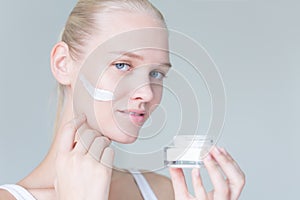 Pretty model woman applying anti aging face cream. Skincare advertisement