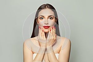 Pretty model woman with red manicured nails on white background. Body care and manicure concept