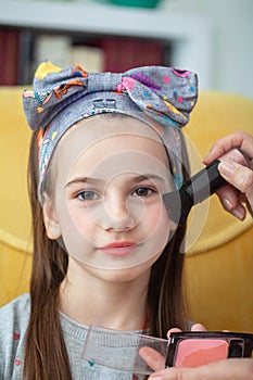 Pretty and modern school girl doing her make up