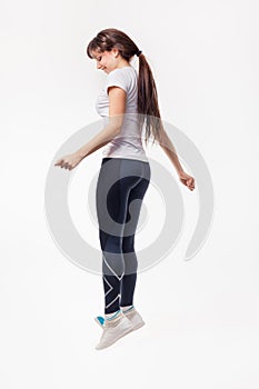 Pretty modern woman jumping dancing isolated on a white studio background