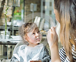 Pretty mother feeding her lovely child