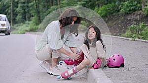 Pretty mother and kid in roller blades on the road