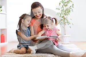 Pretty mother reading book to her daughters