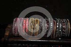 Pretty multi color fashionable glass bangles with tiny reflection of glasses on black floor