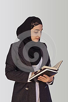 Pretty Muslim businesswoman in hijab holding stack of business documents, notepads. Woman doing business in Islamic word, or