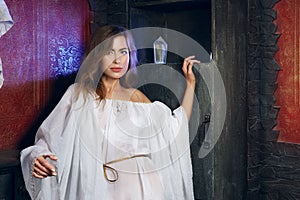 Pretty mystic lady in gothic white dress in underground dungeon