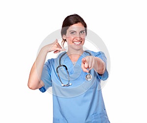 Pretty nurse smiling with a call me gesture