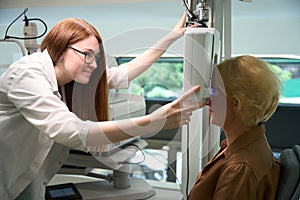 Pretty ophthalmologist uses a dioptermeter in her work