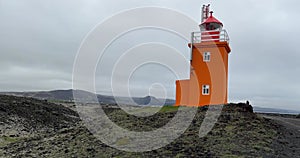 Pretty orange Hopsnes Lighthouse near Grindavik, Iceland on the Reykjanes Peninsula. Side panning establishing shot