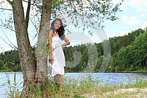 Pretty girl leaning on tree by Dam Rimov