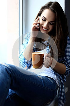 Pretty peaceful young woman using cell phone and