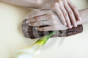 Pretty perfect woman hands with white manicure and big flower on colorful yellow background, spa concept