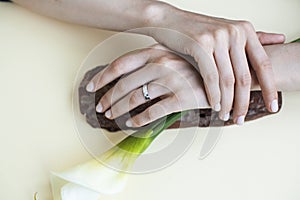 Pretty perfect woman hands with white manicure and big flower on colorful yellow background, spa concept