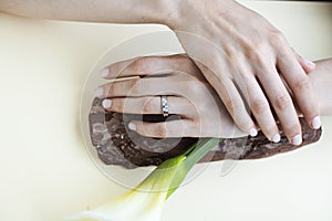 Pretty perfect woman hands with white manicure and big flower on colorful yellow background, spa concept