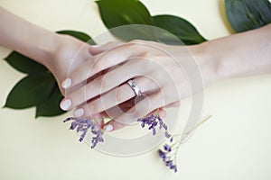 Pretty perfect woman hands with white manicure and little flowers on colorful background