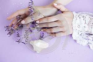 Pretty perfect woman hands with white manicure and little flowers on colorful background