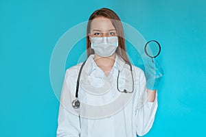 Pretty physician looking through magnifying glass, observing something closely