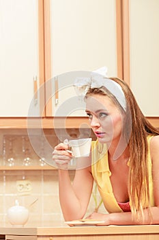 Pretty pin up girl drinking tea or coffee at home.
