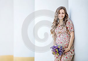 Pretty pregnant woman with a bunch of flowers