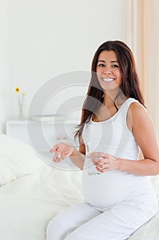 Pretty pregnant woman holding a glass of water