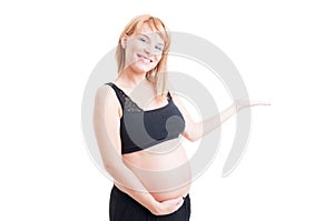 Pretty pregnant woman holding nothing or white advertising copy