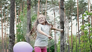 pretty preschool girl having fun playing with hot air balloons outdoors. hollidays, party, birthday, celebration. happy