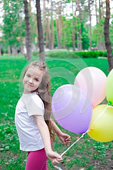 pretty preschool girl having fun playing with hot air balloons outdoors. hollidays, party, birthday, celebration. happy