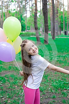 pretty preschool girl having fun playing with hot air balloons outdoors. hollidays, party, birthday, celebration. happy