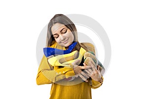 Pretty proud young woman holding many shoes over white background