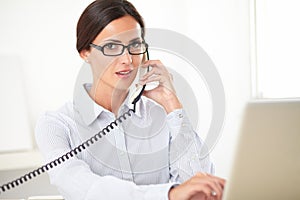 Pretty receptionist using the phone at workplace